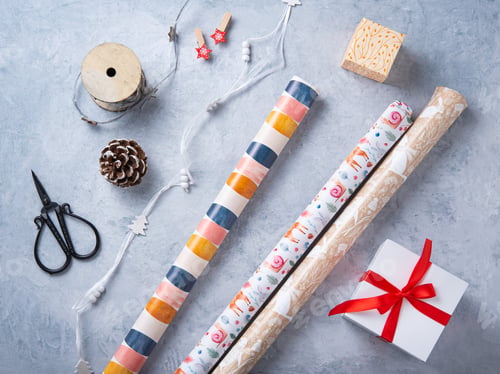 Preview: Christmas flat lay with paper, scissors, box present and wooden toys on blue background