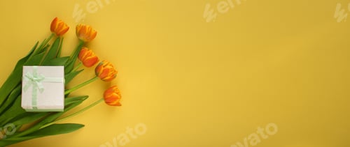 Preview: Orange-red fresh tulips in a bouquet and a gift box on a yellow background.