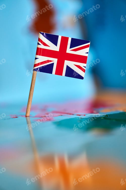 Preview: Closeup of a flag of Great Britain with a small stick on the map