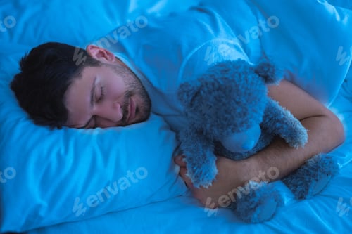 Preview: The man sleeping with a soft toy. evening night time
