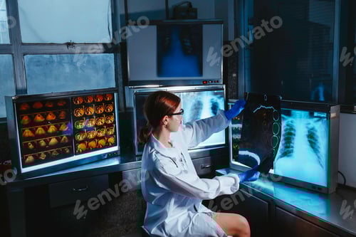 Preview: Female medical radiologist doctor looking head and brain x-ray film before surgery in hospital lab.