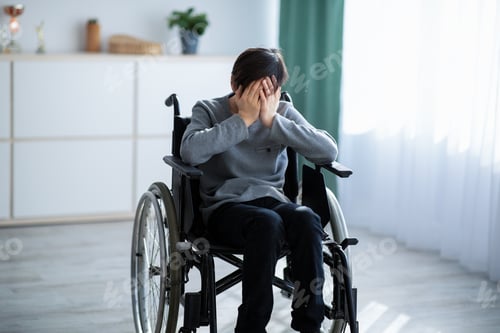 Preview: Depression in teens with disability. Unhappy adolescent in wheelchair crying from loneliness at home