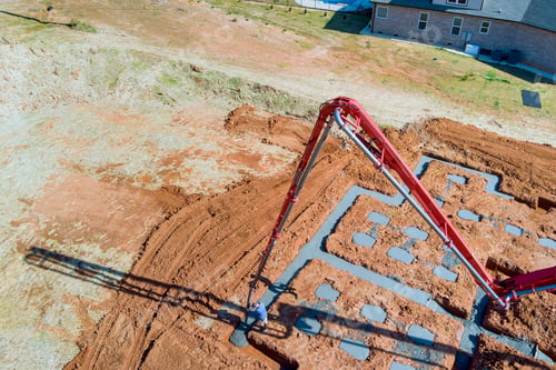 Preview: Wet concrete is being poured into house foundation by builder using a concrete pump.