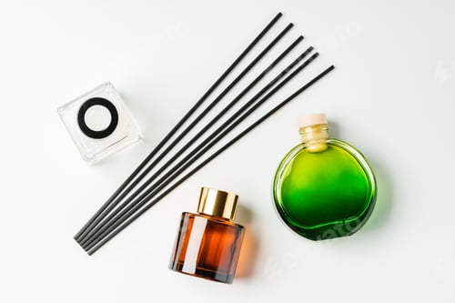 Preview: A minimalist display of essential oil and black diffuser sticks on a clean white background