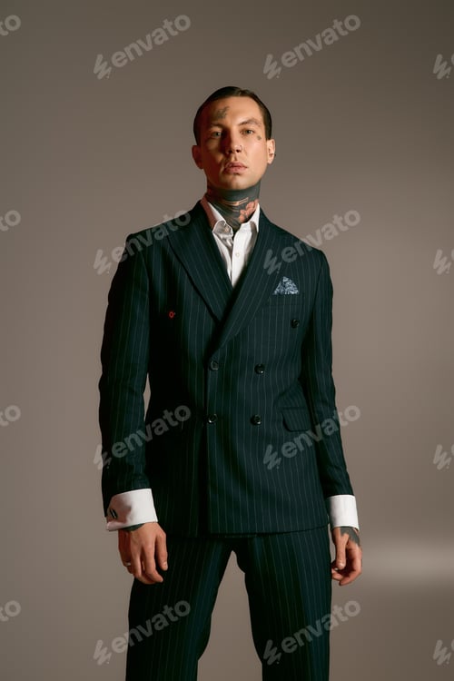 Preview: Stylish young man exuding confidence in a tailored suit against a minimalist backdrop