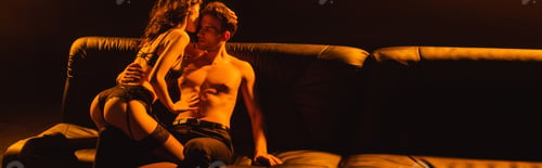 Preview: panoramic crop of brunette woman in underwear sitting on muscular man isolated on black