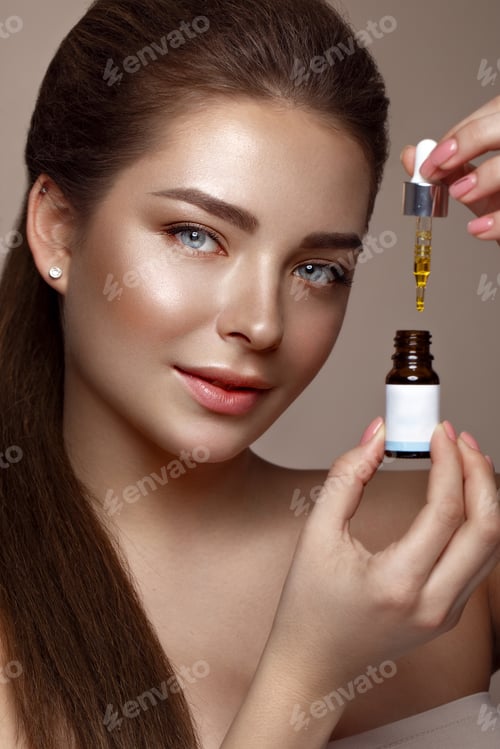 Preview: Woman with Dark Hair Holds Face Serum Dropper