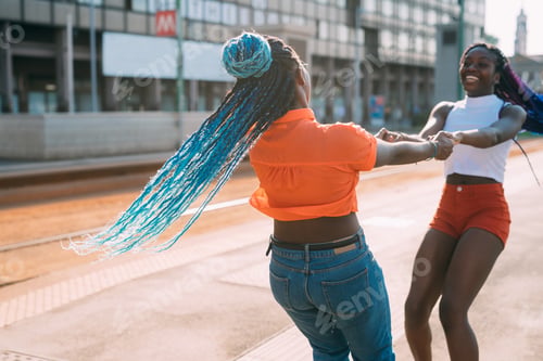 Preview: Two black young sisters outdoors city spinning around holding hands laughing