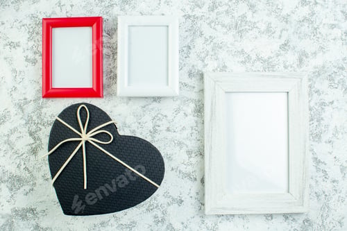 Preview: top view empty photo frames black heart shaped box on grey background
