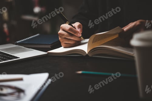 Preview: Businessperson reading and writing on book.education studying knowledge development and cognition
