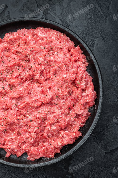 Preview: Fresh raw ground mince beef and pork meat with seasoning on black plate