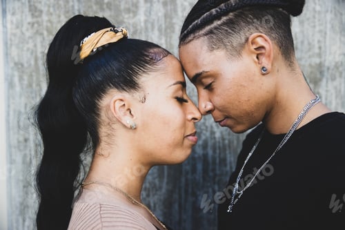 Preview: African American lesbian couple touching foreheads in tender moment together