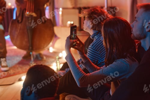Preview: Woman photographing the performance on the phone