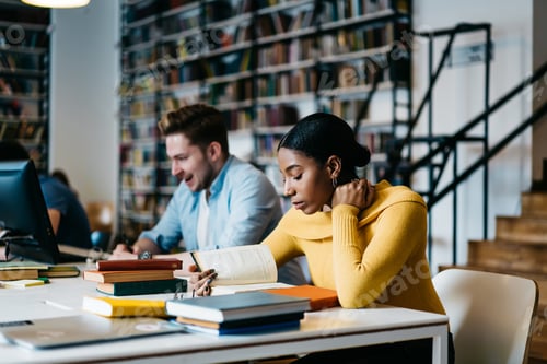 Preview: Thoughtful multiethnic students working in library