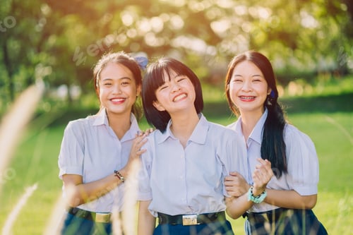 Preview: Group of Asian school teen friend girls in school uniform standing together at green park outdoor