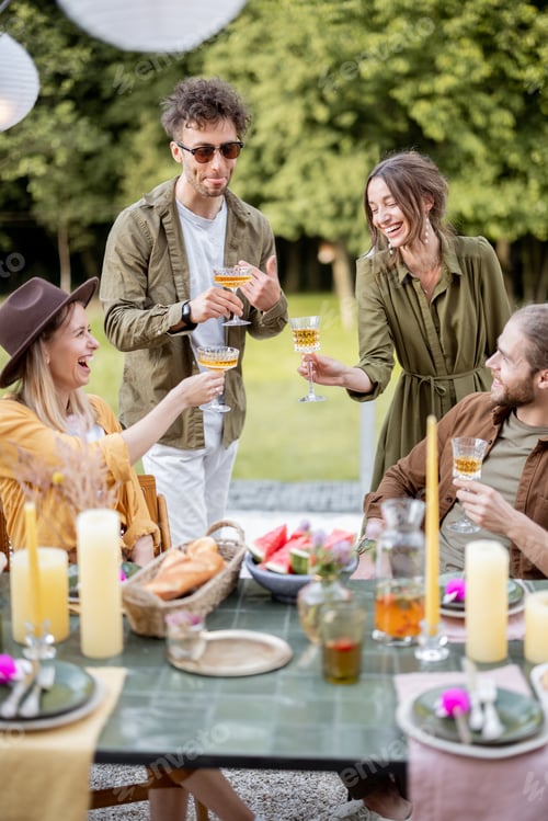 Preview: Young friends dining at backyard of the country house in nature
