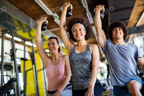Preview: Multiethnic group of people training in a gym. Trainer and sportive fit persons exercising
