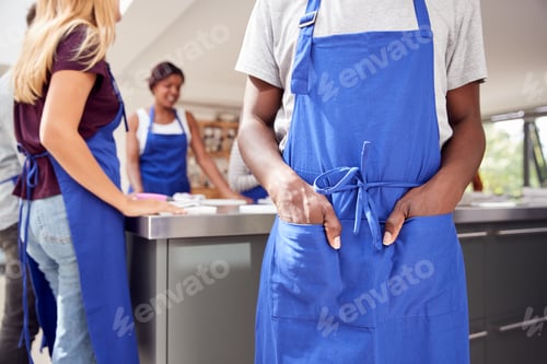Preview: Close Up Of Man With Hands In Apron Pocket Taking Part In Cookery Class In Kitchen