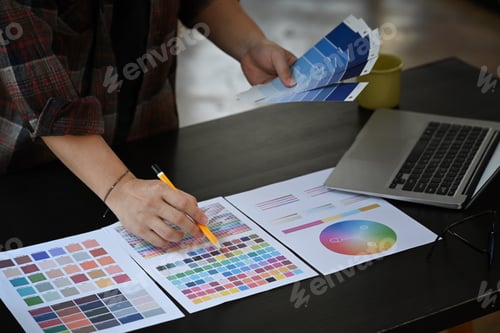 Preview: Graphic designer working with color swatches on office desk.
