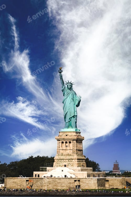 Preview: Vertical landscape of The Statue Of Liberty with white clouds and blue sky