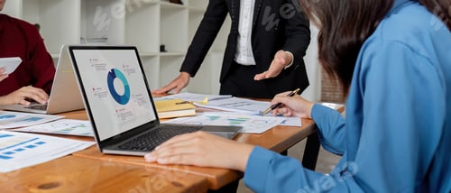 Preview: Business Team Discussing Financial Analysis with Charts and Graphs in Modern Office Setting for