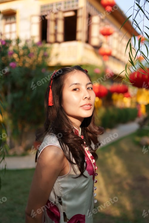 Preview: Happy asian woman in Cheongsam with traditional red lanterns in Chinese temple during new year