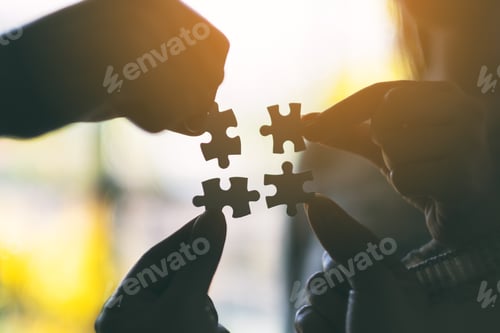 Preview: Silhouette image of many people holding and putting a piece of white jigsaw puzzle together