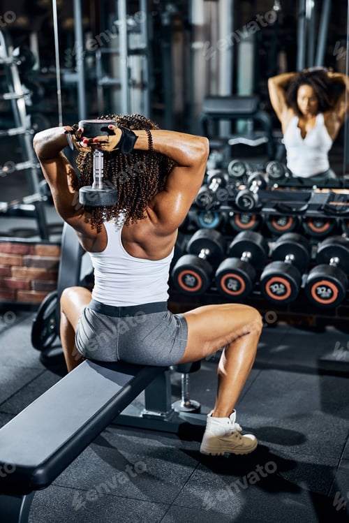 Preview: Female bodybuilder working out in front of the mirror