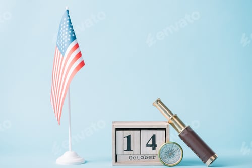 Preview: wooden calendar with October 14 date near American flag, compass and telescope on blue background