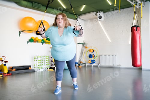Preview: Overweight Woman Using Machines in Gym