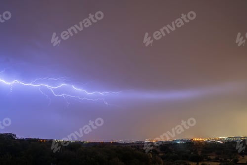 Preview: A spectacular night storm dominates the sky, marked by significant lightning.