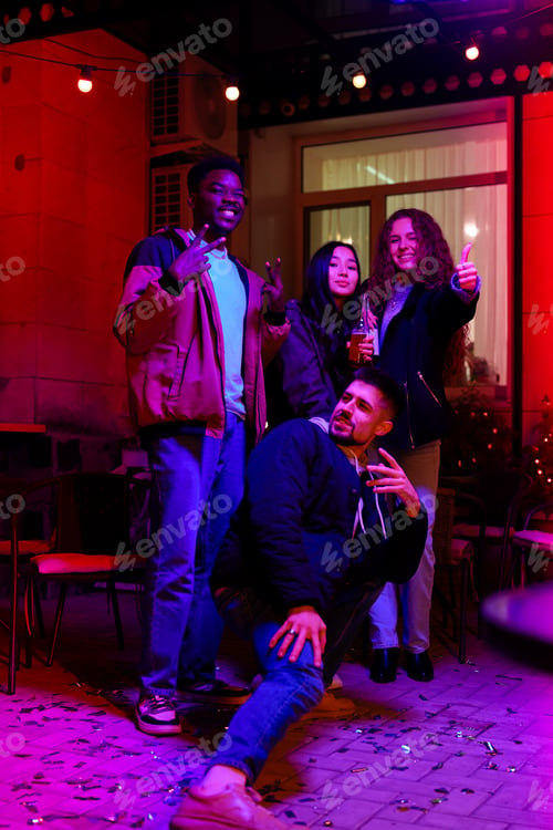 Preview: Group of friends celebrating with drinks and sparklers at a lively outdoor gathering in the evening
