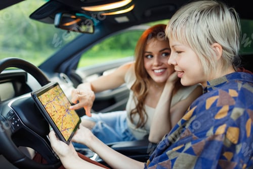 Preview: Happy two women driver tourist travelers with digital tablet USA American map at rental car vehicle.
