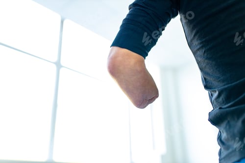 Preview: close up amputee hands of young man indoors doing warm up in gym