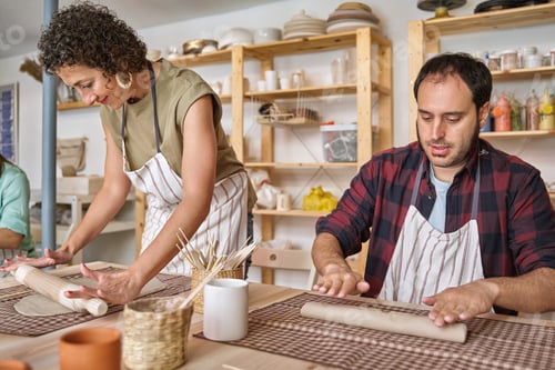 Preview: Two people kneading and shaping clay in a pottery workshop.