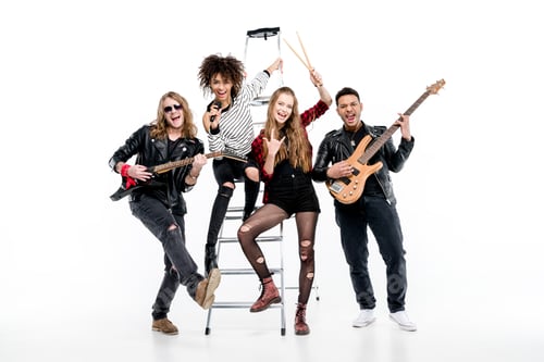 Preview: Young rock and roll band posing with ladder holding microphone and guitars isolated on white