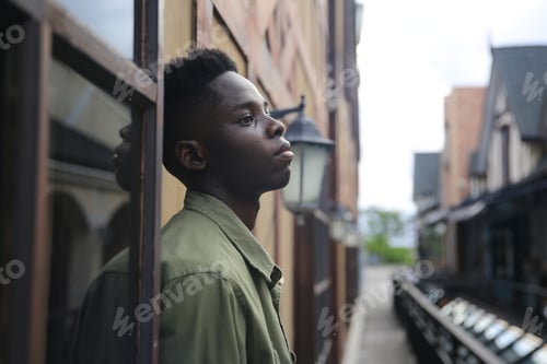 Preview: Afro man standing by wall with sadness