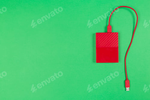 Preview: External hard drive with red casing on green background