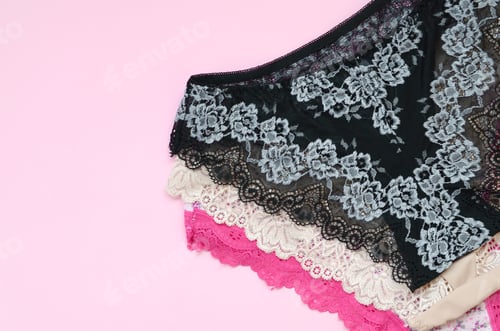 Preview: White, black and pink women underwear with lace on pink background close up with copy space