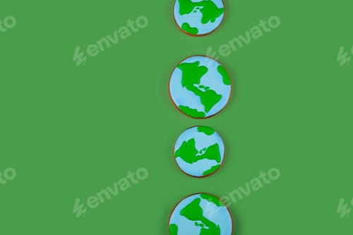 Preview: Earth Day concept. Сookies in shape of Earth on green backdrop. Background with copyspace.