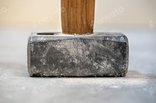 Preview: Closeup shot of a sledgehammer with shallow depth of field on a concrete floor