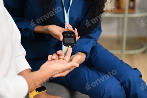 Preview: Nurse checking blood glucose levels of senior diabetic woman during a home visit.