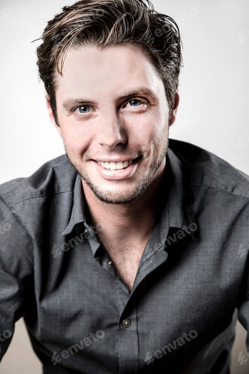 Preview: Smiling man with stylish hair posing for a portrait.