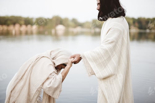 Preview: Shallow focus shot of a female grabbing the hand of Jesus Christ for healing and help