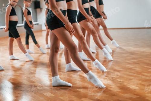 Preview: Group of female kids practicing athletic exercises together indoors