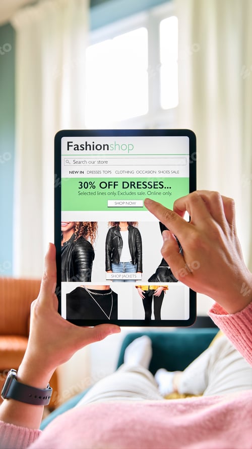 Preview: Close Up Of Woman Shopping For Clothes On Digital Tablet Lying On Sofa At Home
