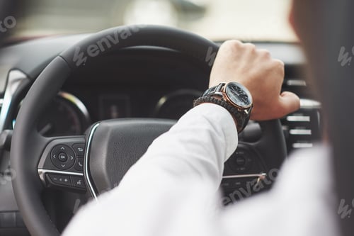 Preview: A businessman rides his car, moves on the wheel. Hand with watch