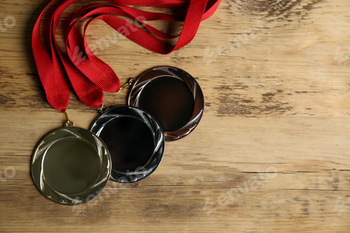 Preview: Gold, silver and bronze medals on wooden background, flat lay. Space for design