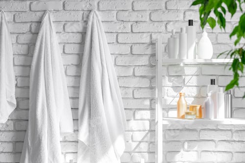 Preview: Cosmetic bottles against white bathroom wall background