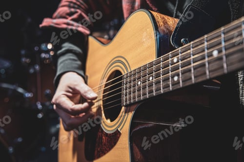 Preview: Guitarist playing acoustic guitar in the dark close up.